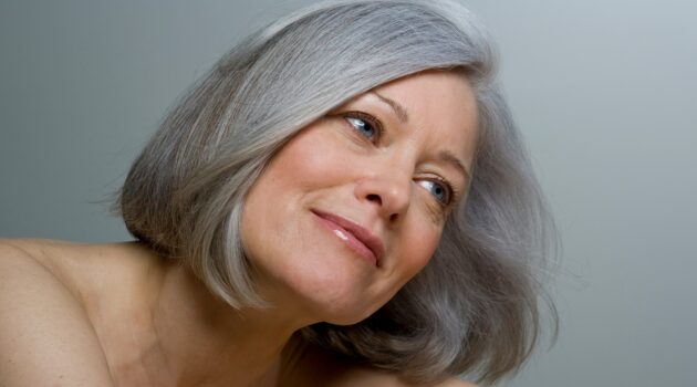 Gros plan sur une femme avec un carré gris lisse et un maquillage naturel