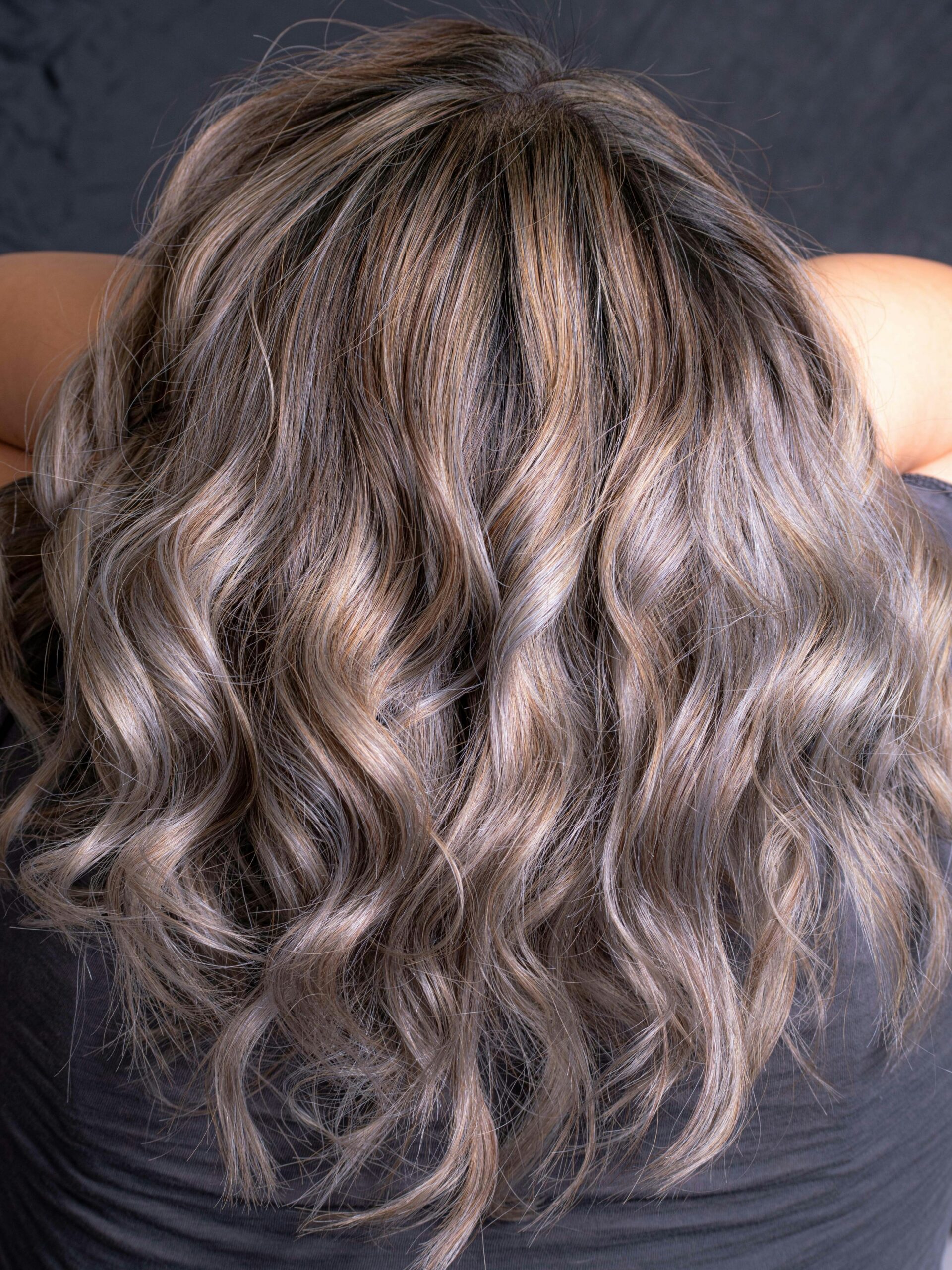 Arrière de la tête d’une femme montrant des cheveux gris ondulés avec un fondu harmonieux