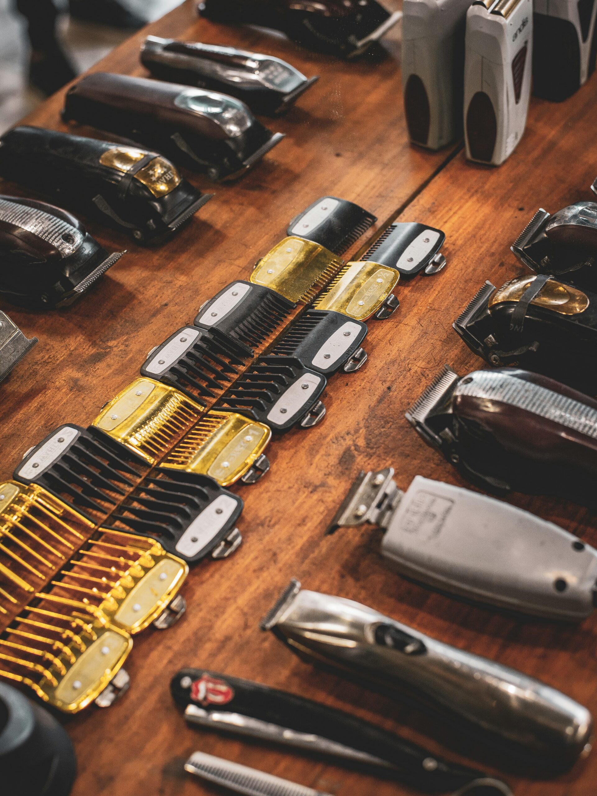 Vue à plat des outils de coiffeur sur une étagère en bois, comprenant tondeuses et sabots