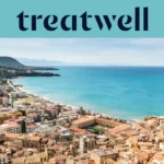 Vue panoramique sur une petite ville côtière sicilienne, avec de vieux bâtiments aux toits de terre cuite, un croissant de plage de sable, une mer turquoise limpide et un promontoire rocheux qui s'élève sur un côté.