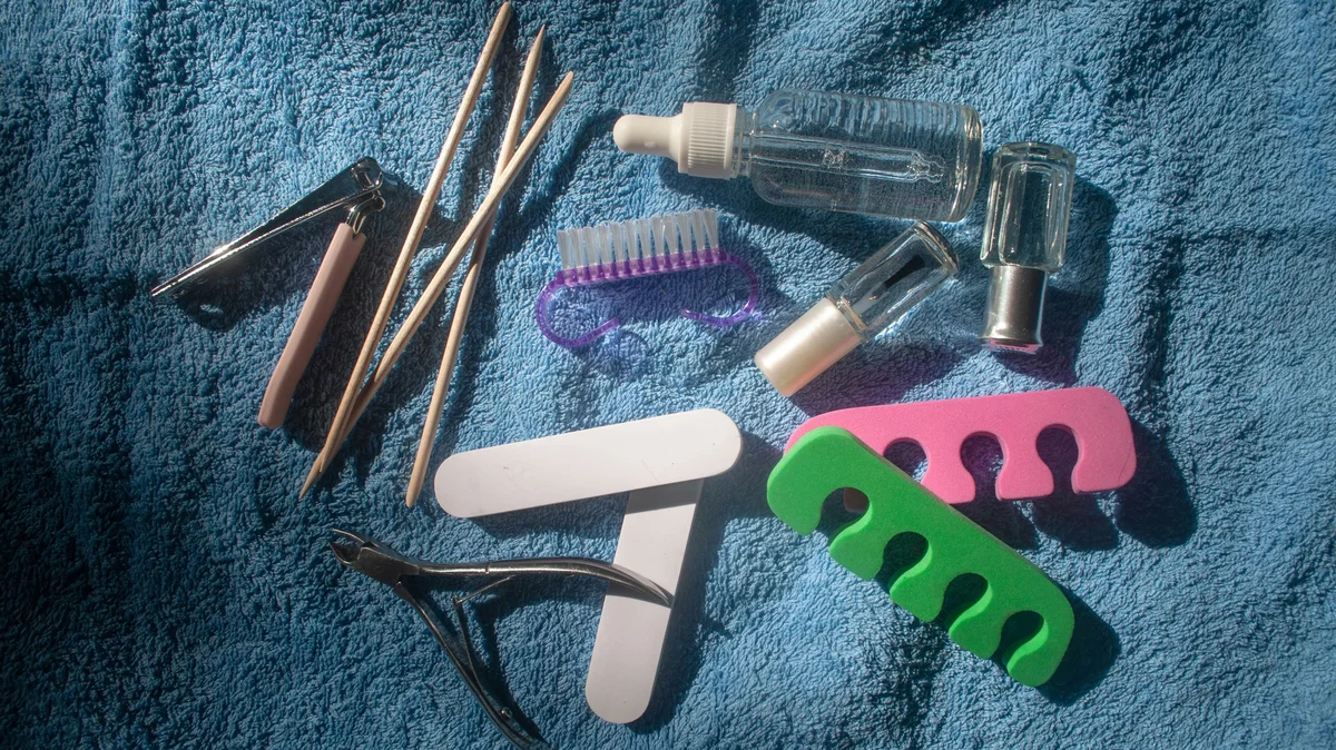 Instruments de soin des pieds photographiés de haut sur une serviette bleue