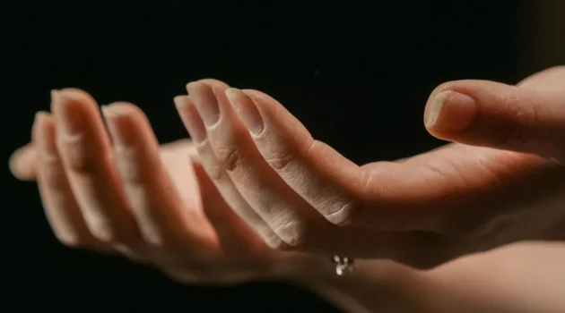 Deux mains tendues, paumes vers le haut, avec des ongles qui se dédoublent