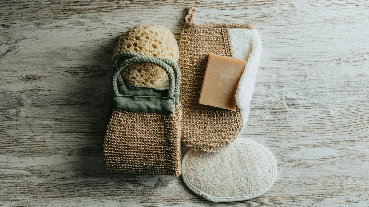Mise à plat de gants exfoliants, d’une éponge naturelle et d’un savon exfoliant