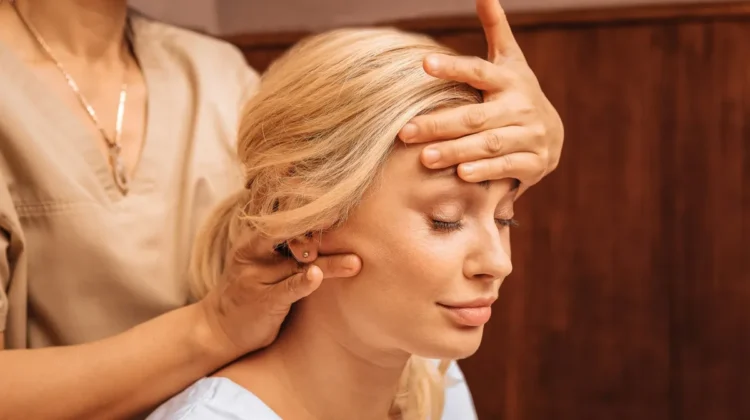 Gros plan sur une femme aux yeux fermés pendant un massage indien de la tête, une praticienne posant une main sur son front et massant sa nuque de l'autre